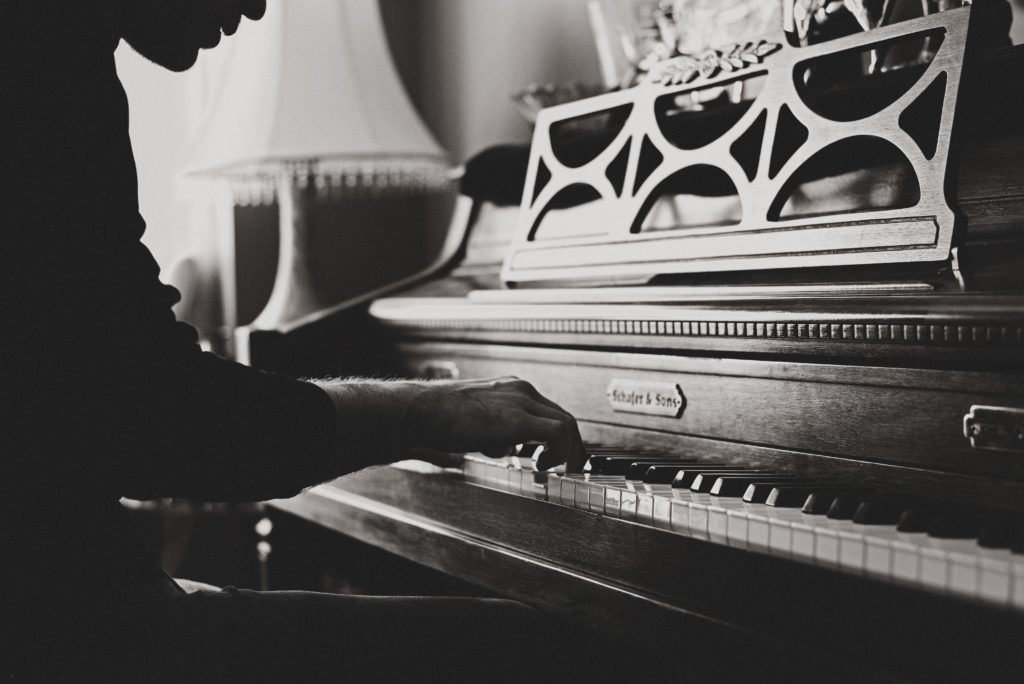 man playing piano black and white