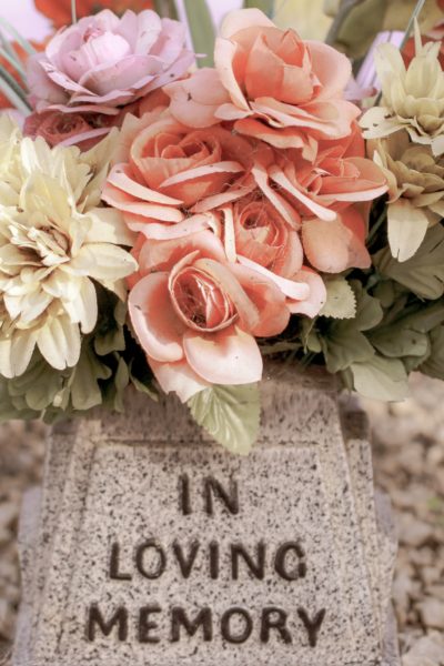 In loving memory gravestone with spring flowers